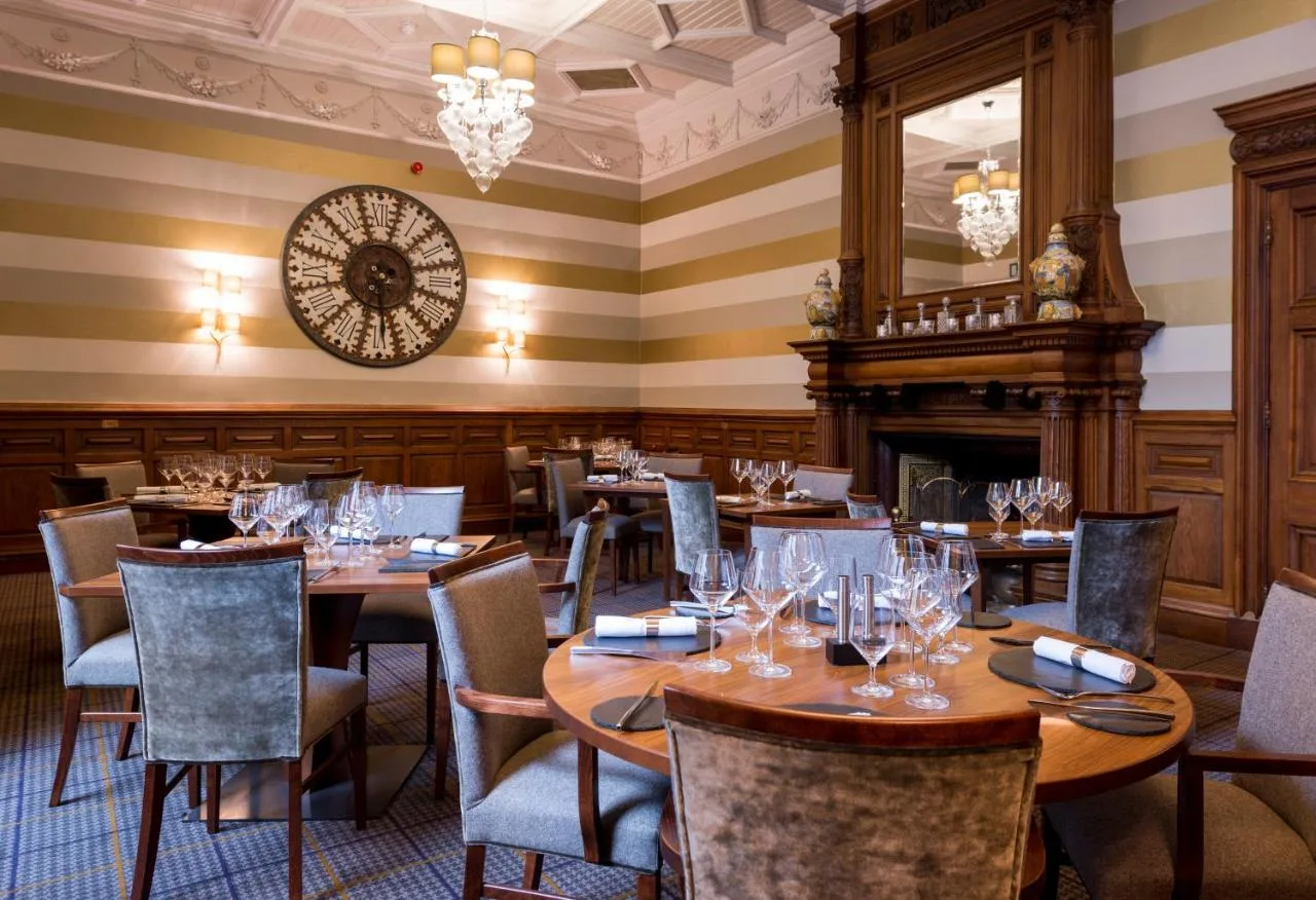 Restaurant with wooden tables, chairs and a clock at Ardoe House Hotel & Spa near Aberdeen